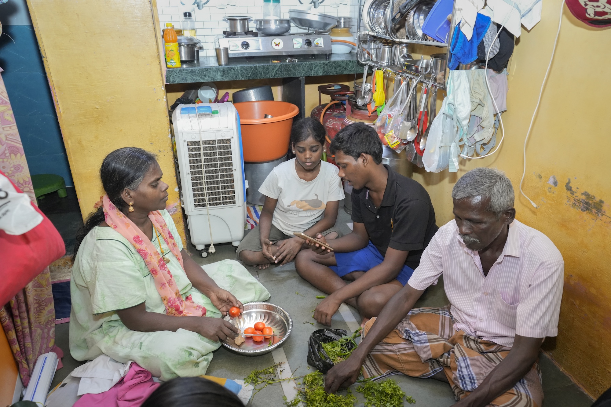 Rekha and her family eating on the floor